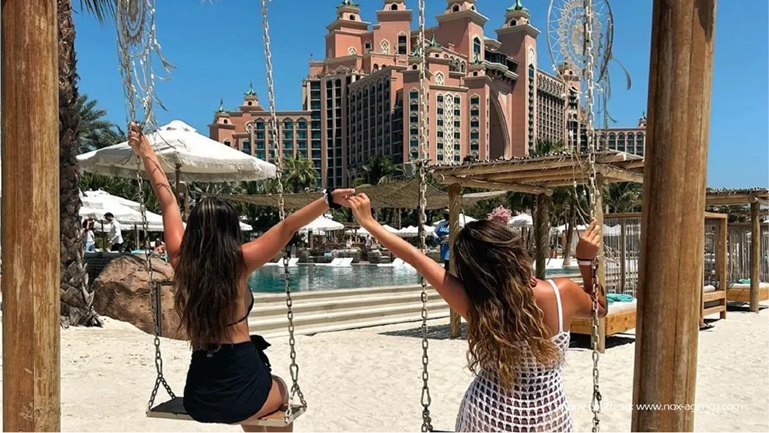 Two friends swinging at Atlantis The Palm, Dubai’s most Instagrammable places.