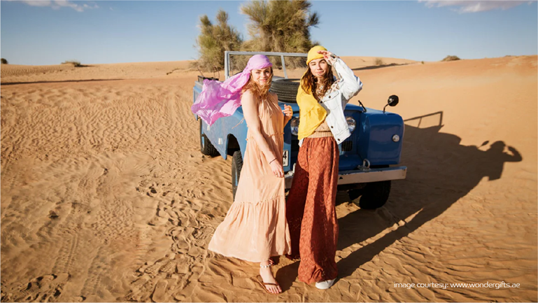 Friends posing near vintage car in Dubai’s desert, most Instagrammable places.